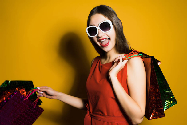 happy girl in a red dress and sunglasses went shopping - Foto, Bild