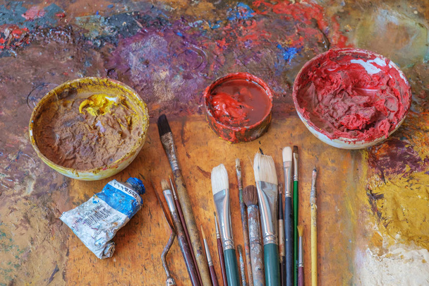 Brushes and oil colors on the used pallete - 写真・画像