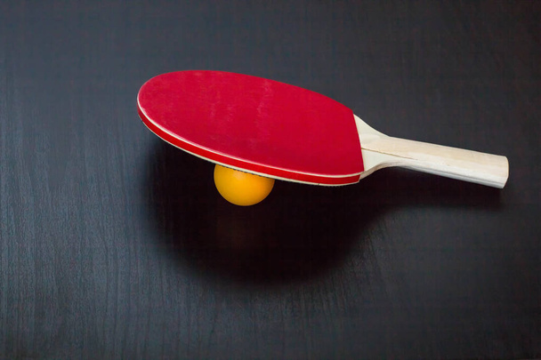 настільний теніс або пінг-понг ракетка і м'яч на чорному фоні
 - Фото, зображення