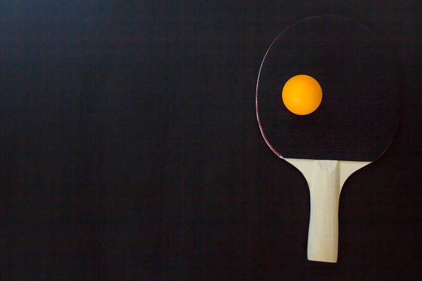 tênis de mesa ou raquete de pingue-pongue e bola em um fundo preto
 - Foto, Imagem