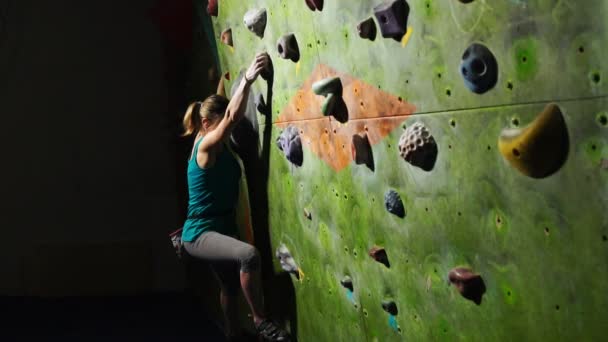 Een vrouw klimmer is opgeleid om obstakels te overwinnen op de muur voor bergbeklimmers. Professionele hulpverlener. Slow motion - Video