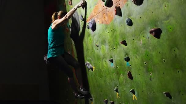 Γκρο πλαν του χεριού του μια γυναίκα ορειβάτης που σκαρφαλώνει τοίχος αναρρίχησης κατά μήκος του τοίχου γλιστρήσουν για διαγωνισμούς χωρίς ασφάλιση. Αργή κίνηση - Πλάνα, βίντεο
