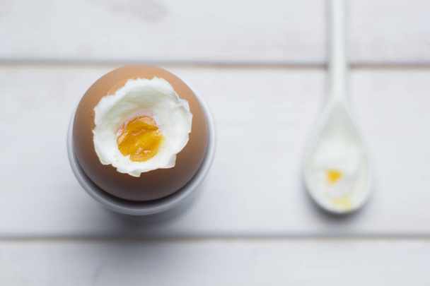 Boiled chicken egg stand, pastern, a spoon on a white background. Easter eggs. - Фото, зображення
