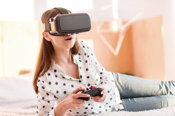 Fascinated young woman dedicating to VR game - Foto, immagini
