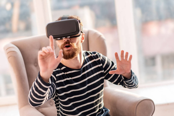 Astonished cool man examining VR - Fotoğraf, Görsel