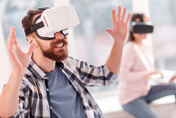 Attractive funny man trying to seize VR objects - Photo, image