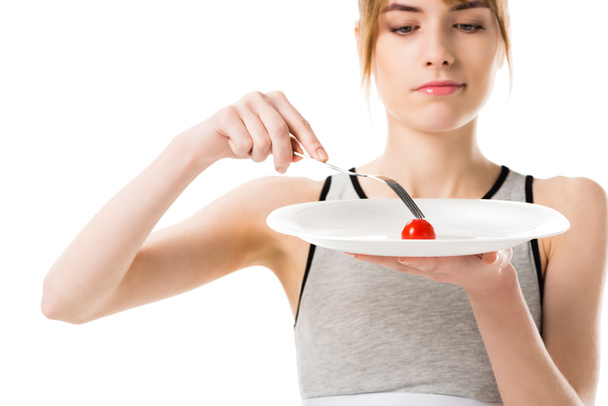 attraktive schlanke Frau isst kleine Kirschtomaten isoliert auf weiß - Foto, Bild
