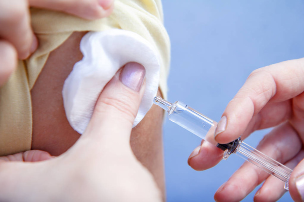 Ruka lékaře držte stříkačku pro očkování na nadloktí p - Fotografie, Obrázek