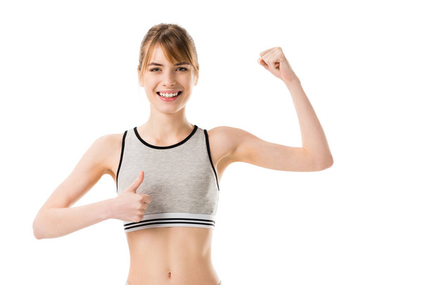 jovem magro mulher mostrando bíceps e polegar para cima isolado no branco
 - Foto, Imagem
