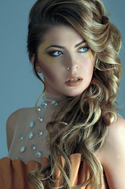 Portrait of beautiful female model on light blue background - Фото, зображення