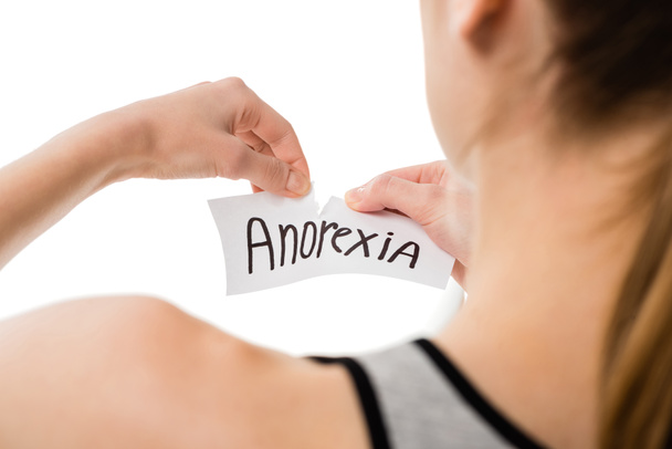 cropped shot of woman tearing paper with anorexia inscription isolated on white - Photo, Image