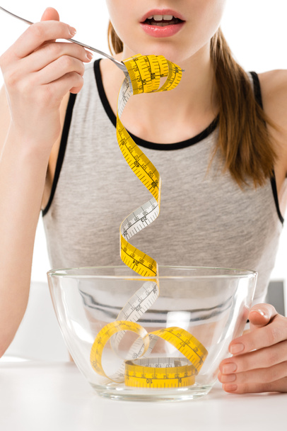 oříznuté záběr ženy jíst přiváděných pásky izolované na bílém, anorexie koncepce - Fotografie, Obrázek