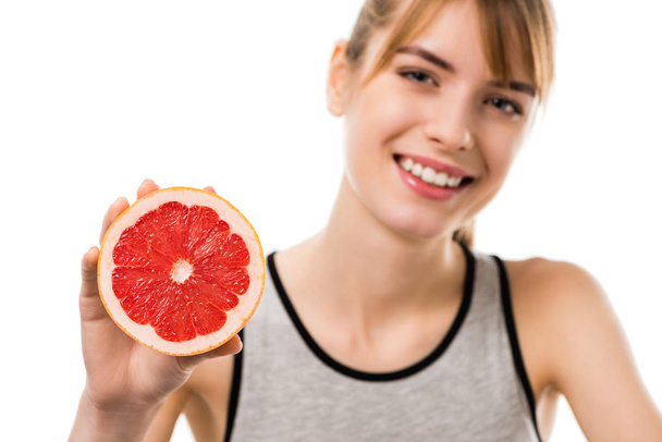 young happy woman with half of grapefruit isolated on white - 写真・画像