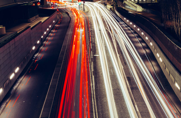 Ciudad senderos ligeros de tráfico de coches en movimiento rápido en la carretera en Londres por la noche
 - Foto, imagen