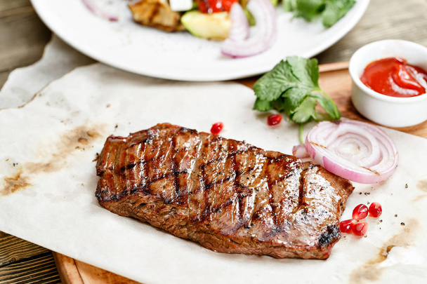 大理石の牛肉のステーキのグリル。素朴なテーブルに木の板を提供します。バーベキュー レストランのメニューの一連の別の肉の写真 - 写真・画像