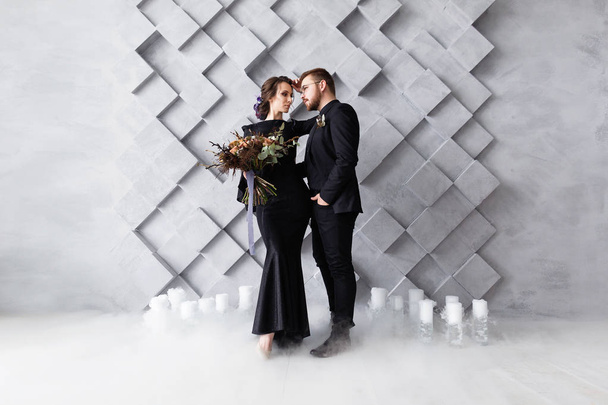 Γάμου ζευγάρι, νύφη και γαμπρός μόδα πορτρέτο, πάνω από το γκρίζο φόντο ογκομετρική με copyspace. Καπνού ξηρού πάγου. - Φωτογραφία, εικόνα