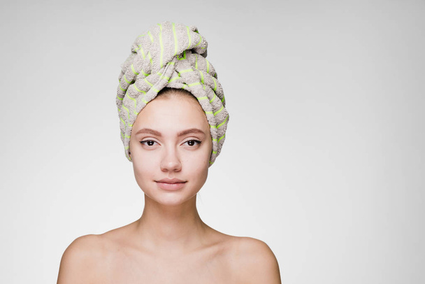 a surprised woman with a towel on her head posing on the camera - Foto, Imagen