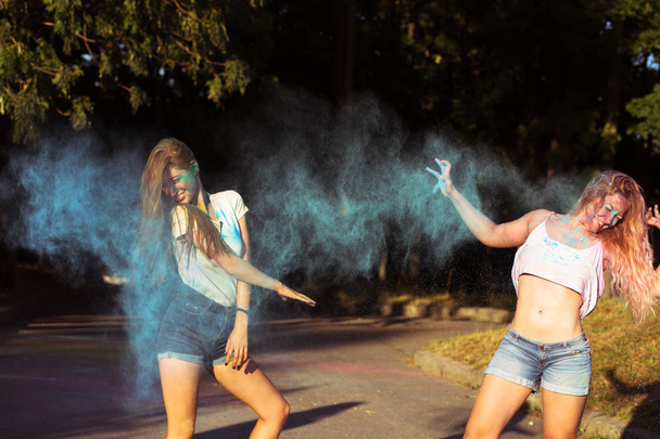 Two funny young woman friends having fun with exploding Holi pow - Foto, Imagem