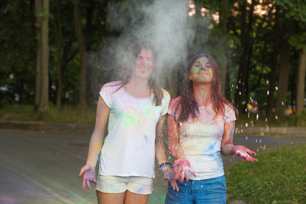 Δύο happy φίλοι διασκεδάζουν με σκόνη Holi στο πάρκο  - Φωτογραφία, εικόνα