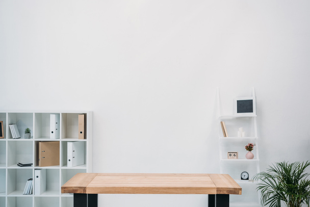 современный офисный интерьер с пустым деревянным столом и папками на полках
 - Фото, изображение