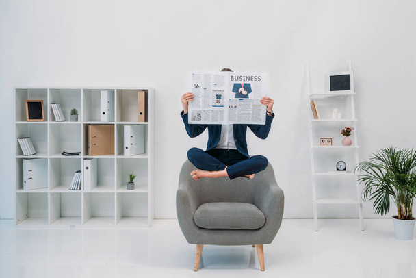 businesswoman reading newspaper while levitating in office - Zdjęcie, obraz
