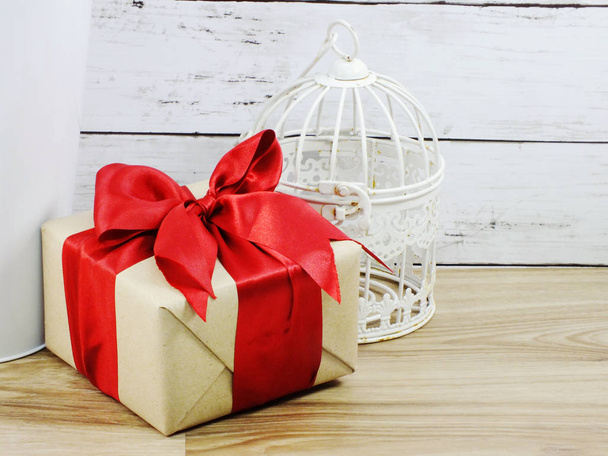 wrapped vintage gift box with red ribbon bow and bird cage home decoration - Fotoğraf, Görsel