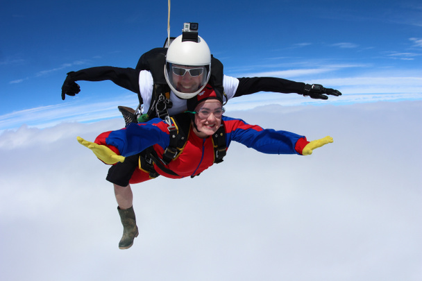 Paraşütle atlama. Gökyüzünde uçan kız-yolcu ve eğitmen. - Fotoğraf, Görsel