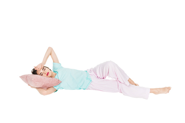 κορίτσι με τις πυτζάμες ξαπλωμένο στο μαξιλάρι με κλειστά τα μάτια που απομονώνονται σε λευκό - Φωτογραφία, εικόνα