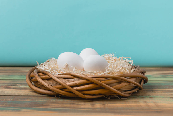 Pasen eieren op houten achtergrond, bovenaanzicht, kopieer ruimte. Pasen stilleven. Pasen decor. Kwartel Pasen eieren in een nest op houten tafel met copyspace voor de groeten van tekst. - Foto, afbeelding