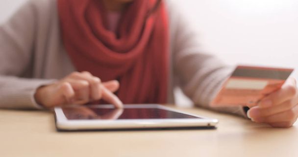 Женщина с помощью планшетного компьютера для покупок в Интернете на столе
  - Фото, изображение