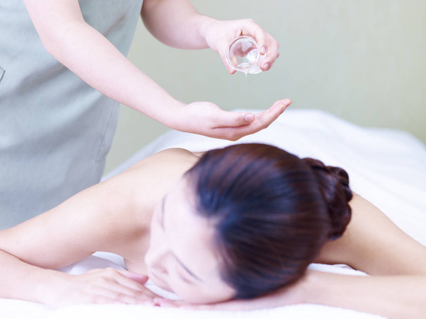 massaggiatore performing olio massaggio su giovane asiatico donna
 - Foto, immagini