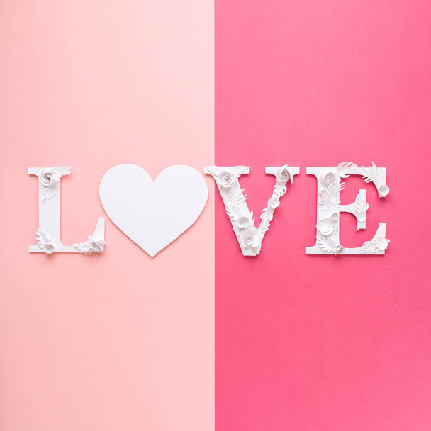 Photo inscription love made of leaves and flowers on pink background - Foto, Imagem
