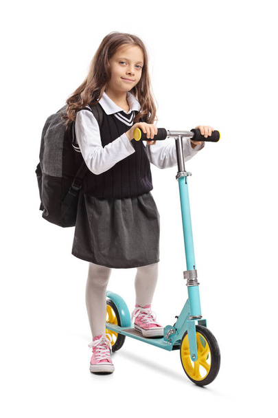 Full length portrait of a schoolgirl with a scooter isolated on white background - 写真・画像