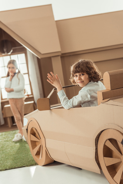 happy little kid arrived for girlfriend on cardboard car - Foto, Imagen