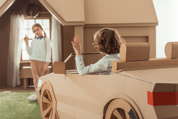 little kid arrived for girlfriend on cardboard car - Foto, Imagen
