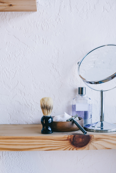 close up view of arranged barber equipment for shaving on wooden shelf - Photo, Image