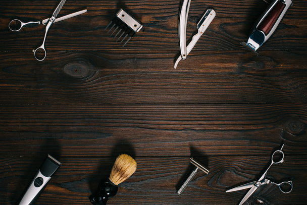 top view of arrangement of various barber tools on wooden tabletop - Photo, Image