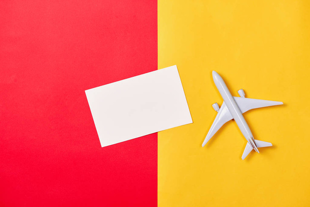 άσπρο παιχνίδι αεροπλάνο και κενή κάρτα στο χρώμα φόντου - Φωτογραφία, εικόνα