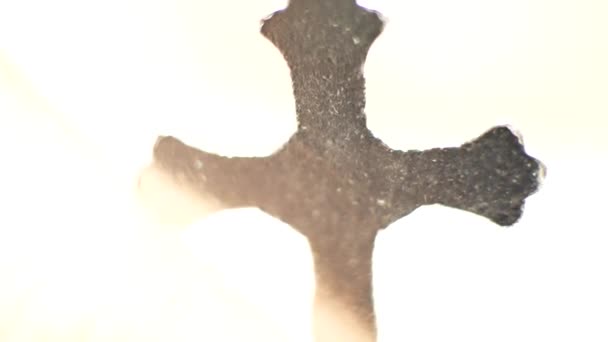 Kreuz auf weißem Hintergrund verschwindet in Lichtstrahlen - Filmmaterial, Video