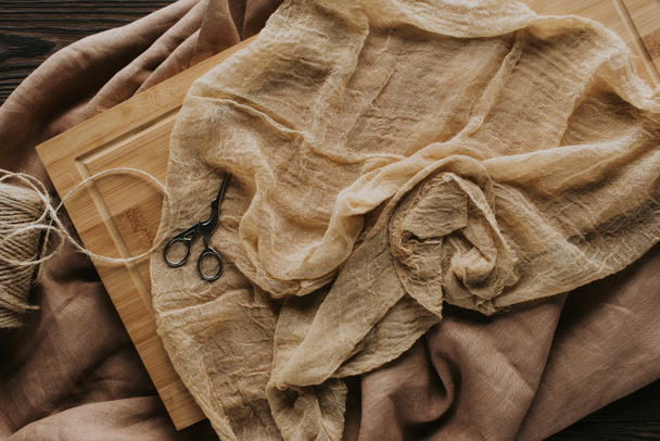 vista superior de cordel y tijeras vintage en mantel y tablero de madera
  - Foto, Imagen