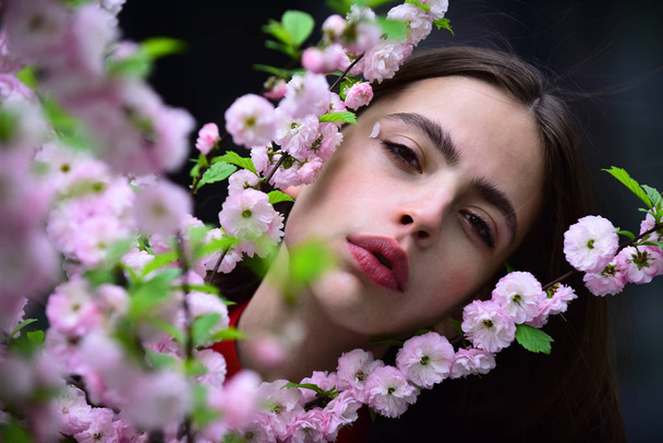 Girl with blossoming sakura on spring day - Valokuva, kuva