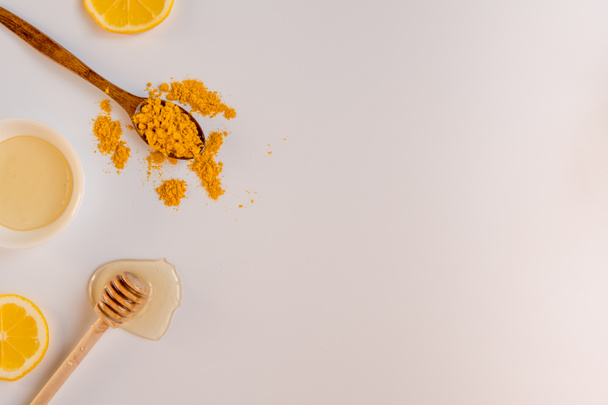 Honey stick, spoon with turmeric and lemon slices top view, copy - Photo, Image