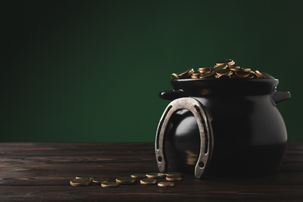 κατσαρόλα με χρυσά νομίσματα και πέταλο στο τραπέζι, st patricks ημέρα έννοια - Φωτογραφία, εικόνα