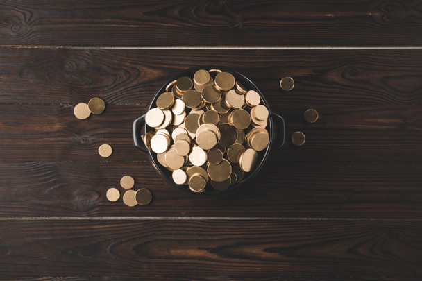 vista superior do potenciômetro com moedas douradas na tabela de madeira, st patricks conceito do dia
 - Foto, Imagem
