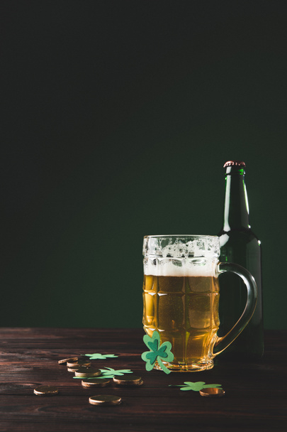 glass of beer with bottle and golden coins on table, st patricks day concept - Foto, imagen