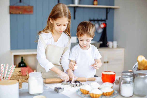 Happy family sister and brother baking cookies in the kitchen. - Foto, Imagen