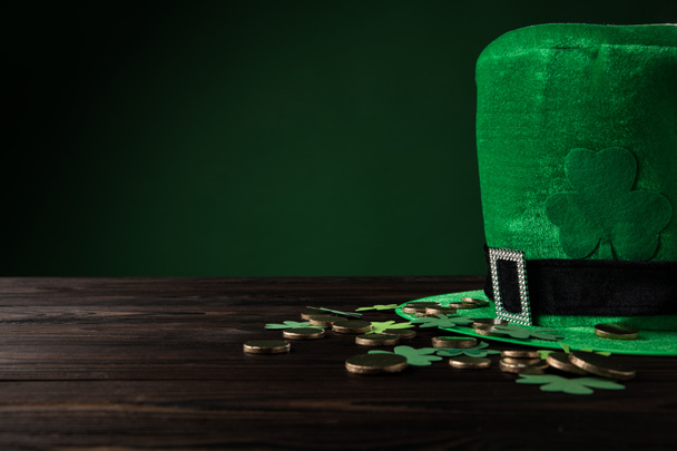 Altın sikkeli yeşil şapka ve tahta masa üzerinde yonca Aziz Patrick Günü konsepti. - Fotoğraf, Görsel