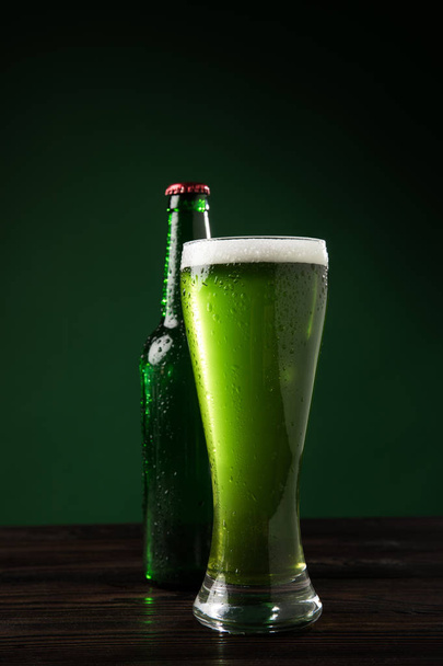 glass bottle and glass of green beer on table, st patricks day concept - Fotó, kép