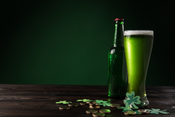 γυάλινο μπουκάλι και ποτήρι πράσινο μπύρα με νομίσματα στο ξύλινο τραπέζι, st patricks ημέρα έννοια - Φωτογραφία, εικόνα