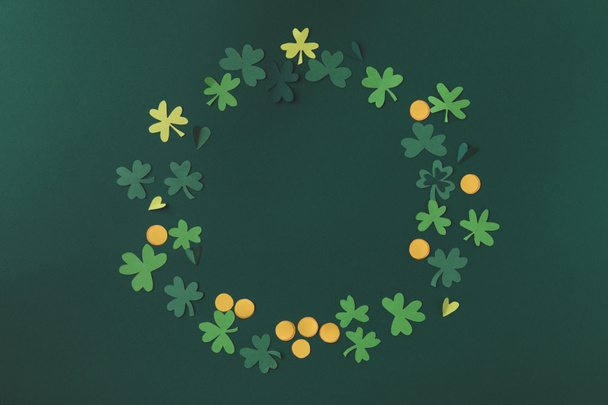 top view of paper decoration of coins and shamrock for st patricks day isolated on green - Photo, Image